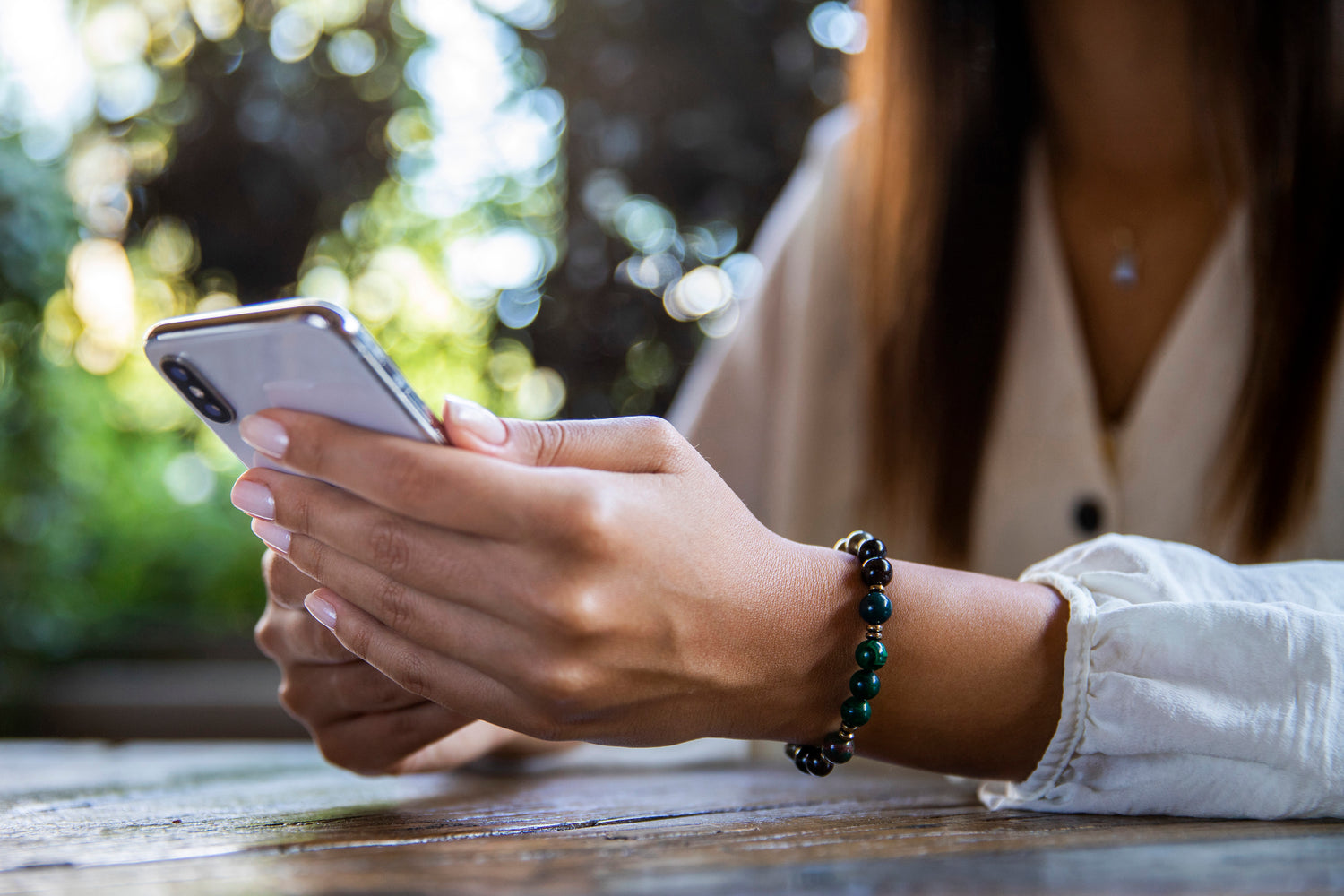 Girl holding a phone with fortune bracelet