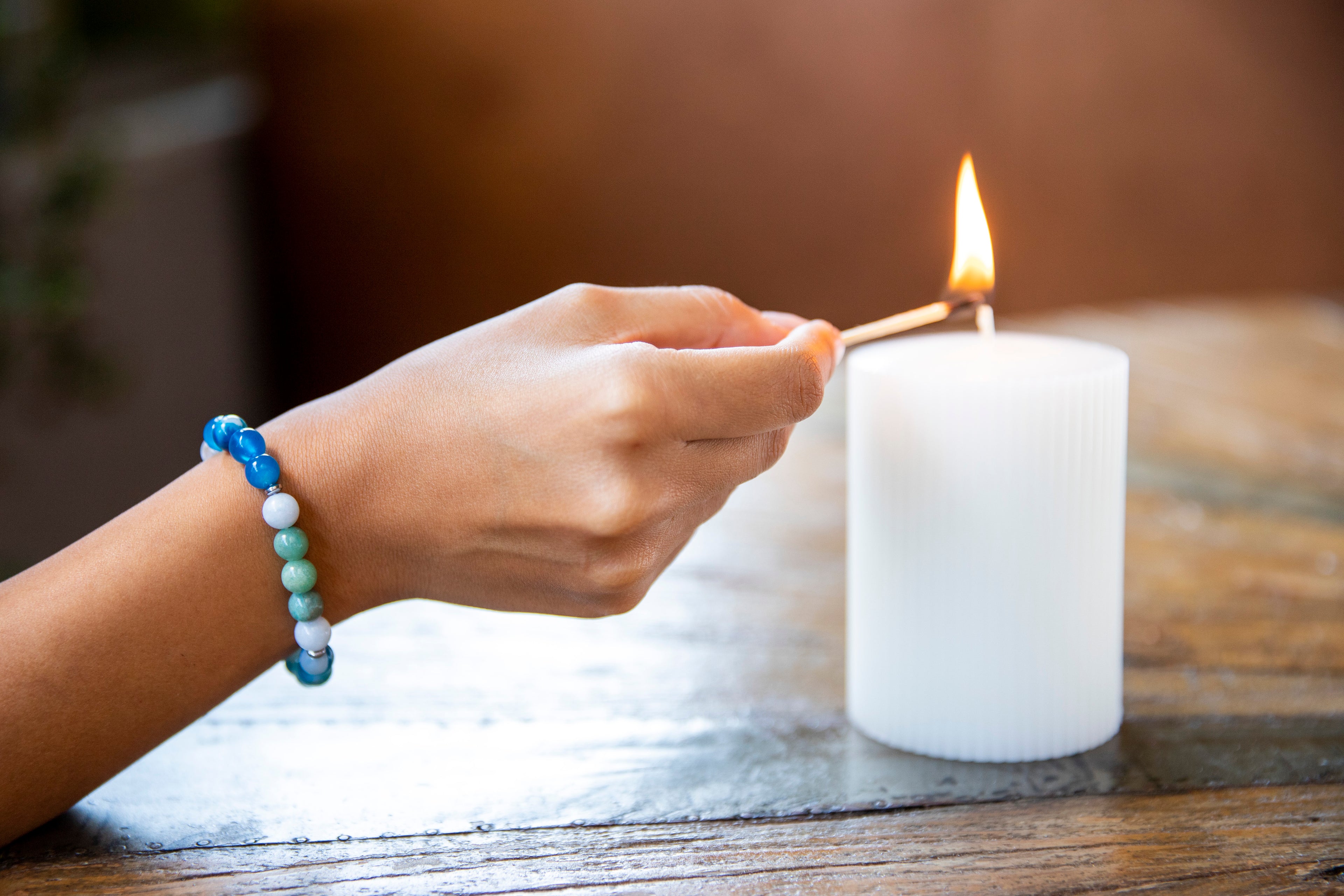 Girl lighting candle with balance bracelet