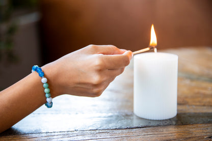 Girl lighting candle with balance bracelet