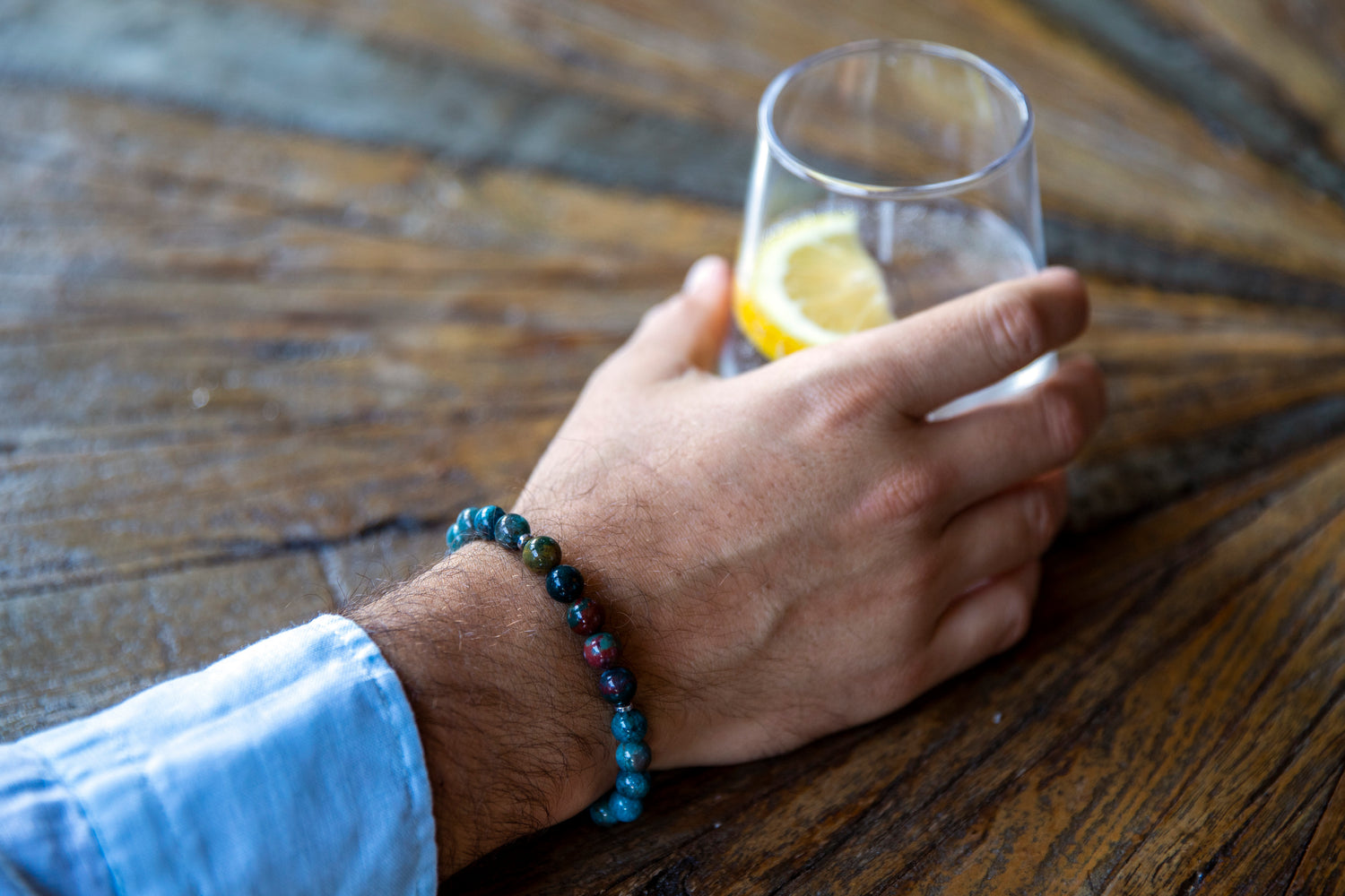men drinking water with lemon wearing blue gemstone bracelet