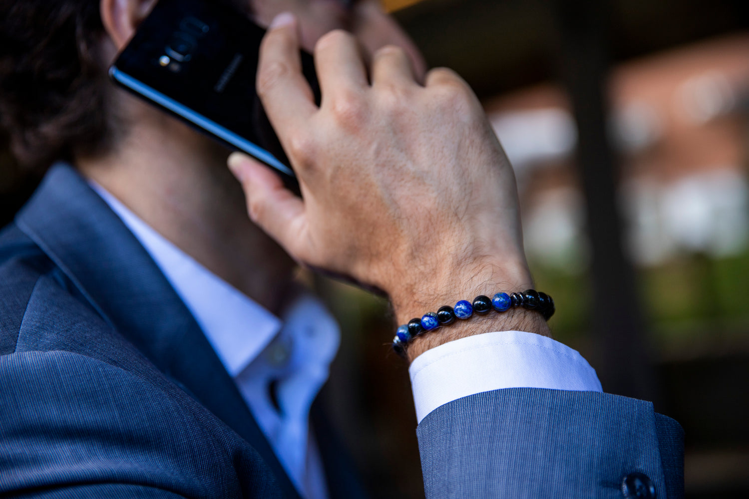 Men talking on the phone with protection bracelet