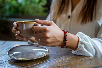 woman drinking coffee with gemstone beaded healing bracelet for energy and vitality