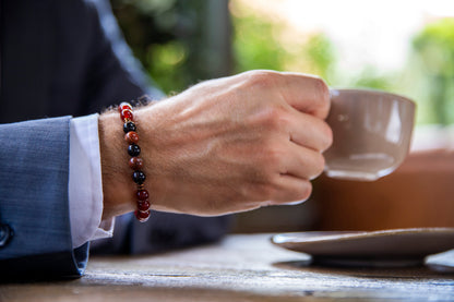 Men drinking coffee with gemstone beaded healing bracelet for energy and vitality